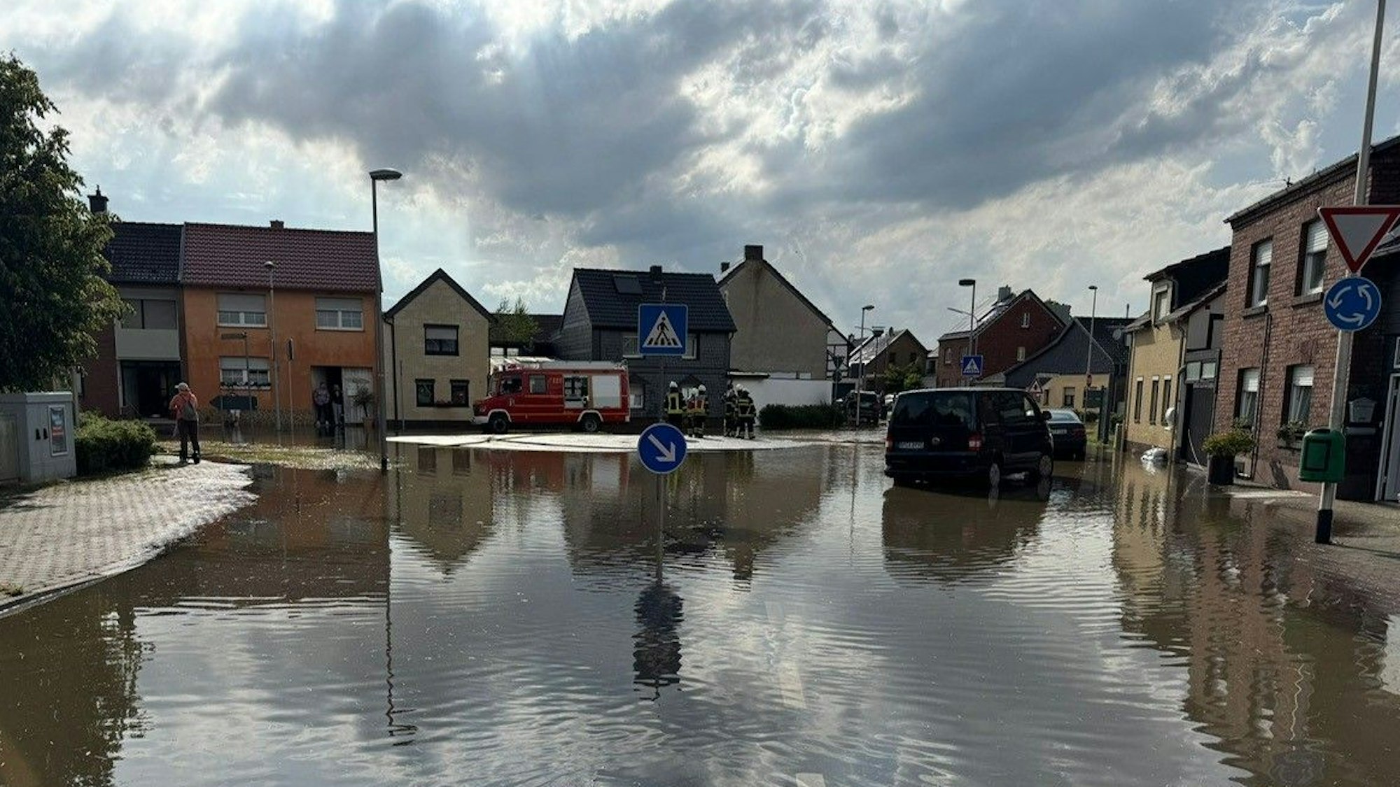 Das Bild zeigt einen Dorfplatz, der unter Wasser steht.