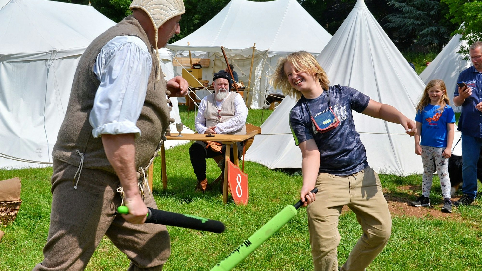Ein Junge und ein Mann befinden sich im Schaumstoffschlägerduell.