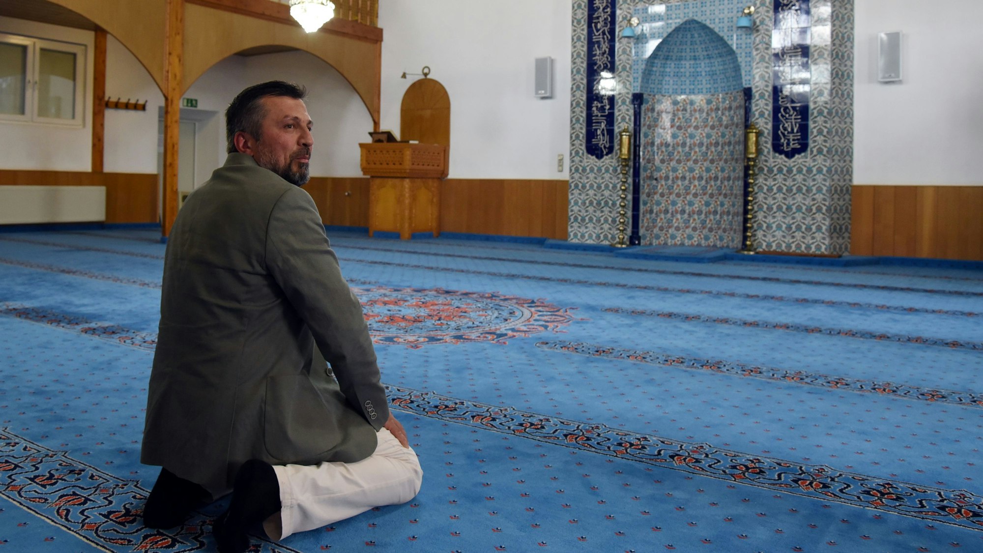 Recep Özgül, Sprecher des Moscheevereins, demonstriert im Bergneustädter Gebetsraum den Abschiedsblick beim Gebet.