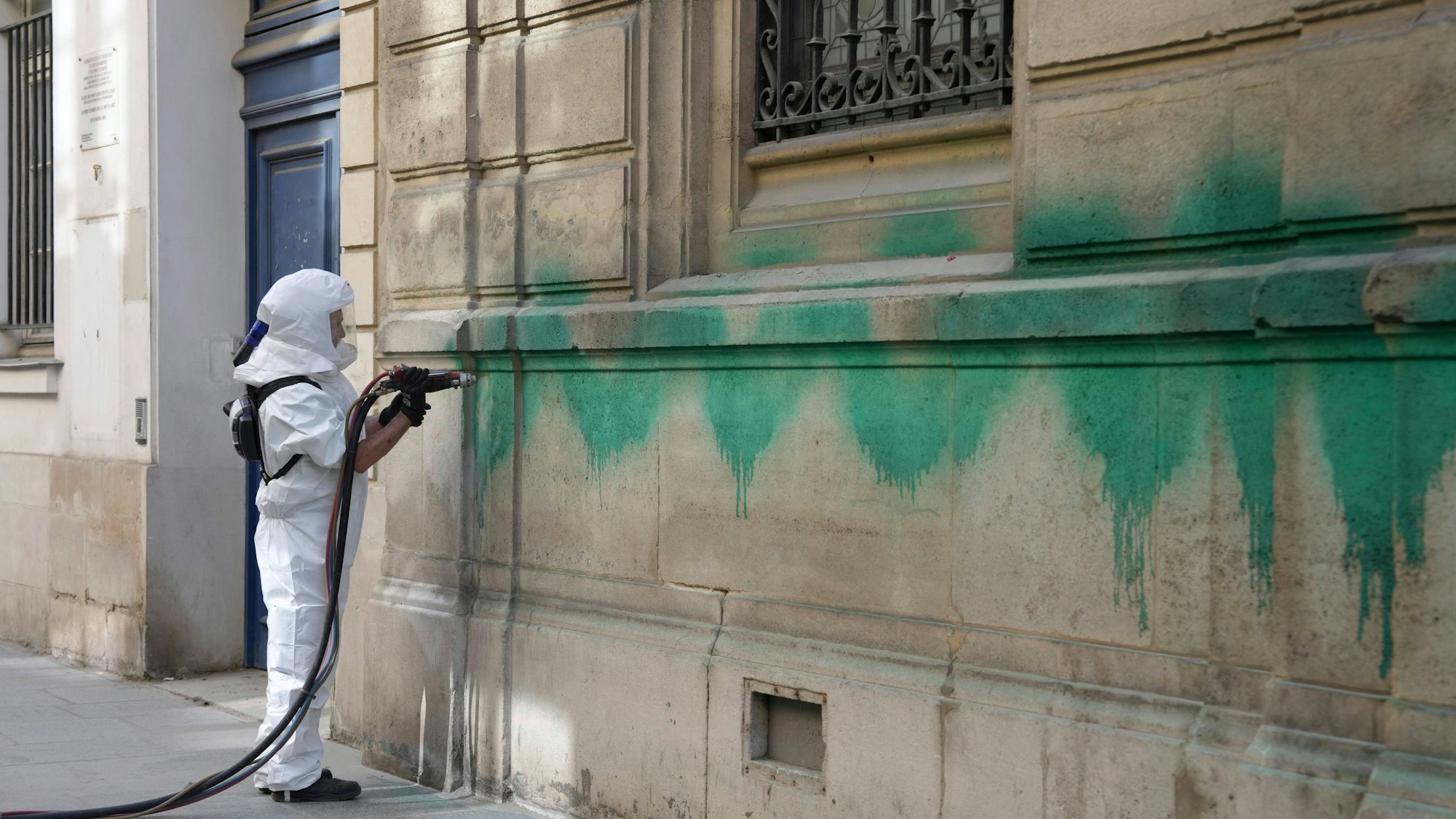 Ein Arbeiter reinigt die mit grüner Farbe verunstaltete Synagoge des Tournelles, nachdem mehrere jüdische Stätten in der Hauptstadt mit grüner Farbe verunstaltet worden waren.