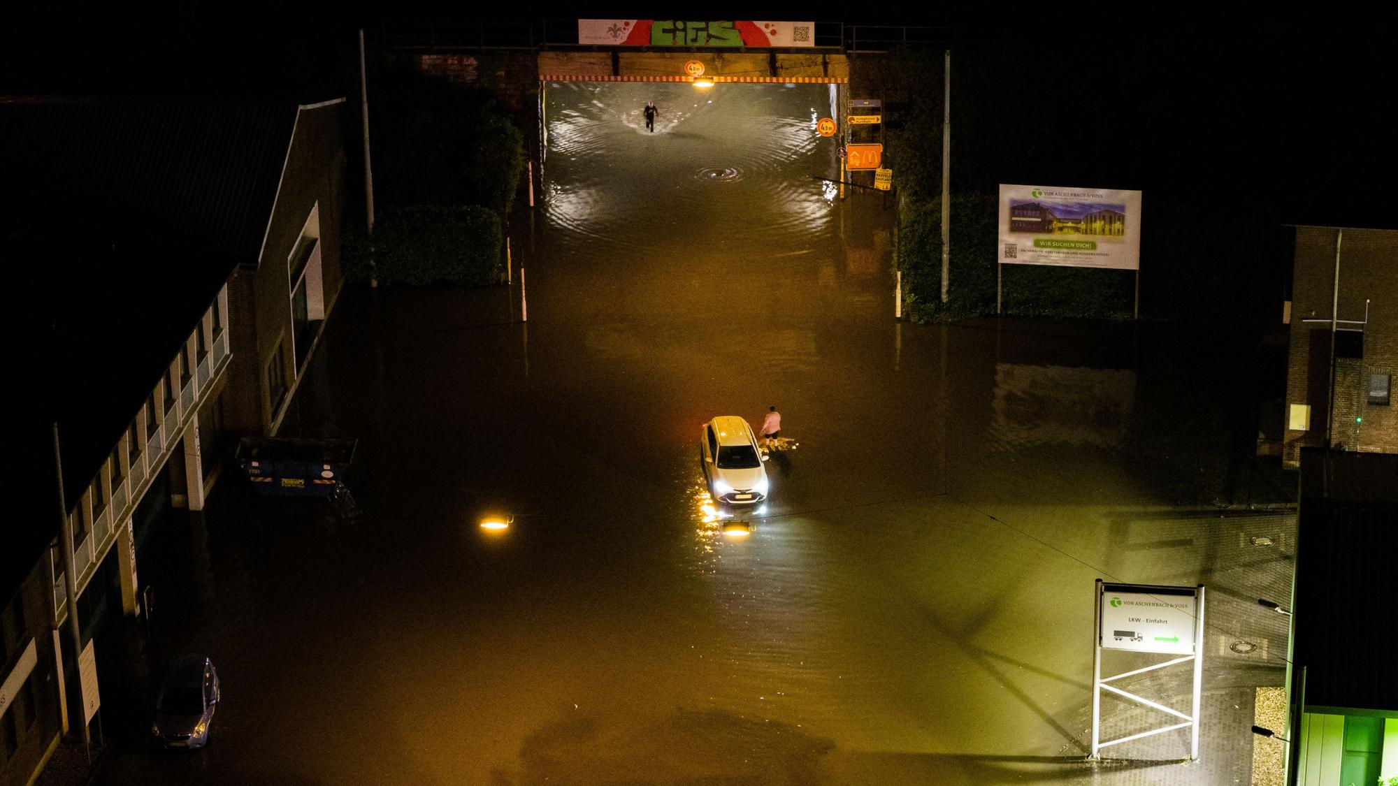 Ein Auto steckt im Hochwasser bei einer überfluteten Unterführung in Krefeld fest. Nach einem Gewitter mit heftigem Wind und Starkregen gab es mehrere Sperrungen durch die umgefallene Bäume und überflutete Straßen.