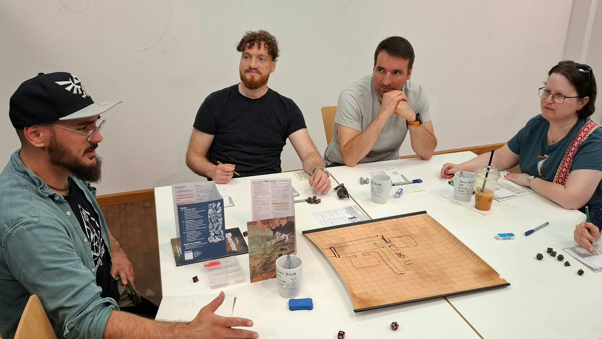 Spielleiter Alessandro Serafino mit einigen Spielern am Tisch