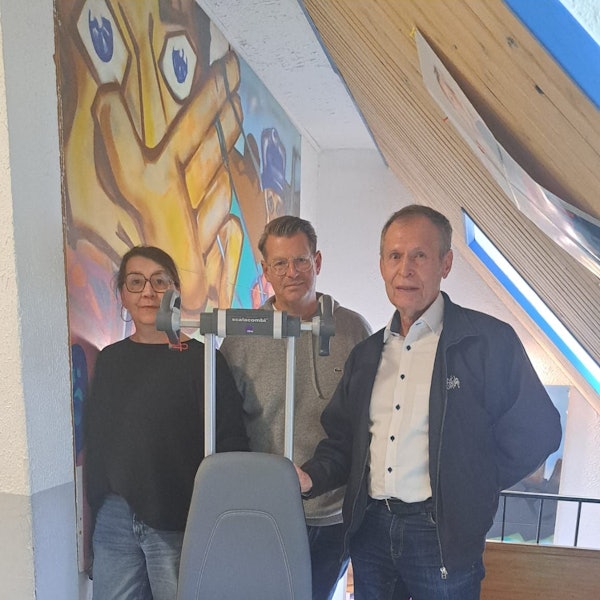 Eine Frau und zwei Männer stehen nebeneinander.