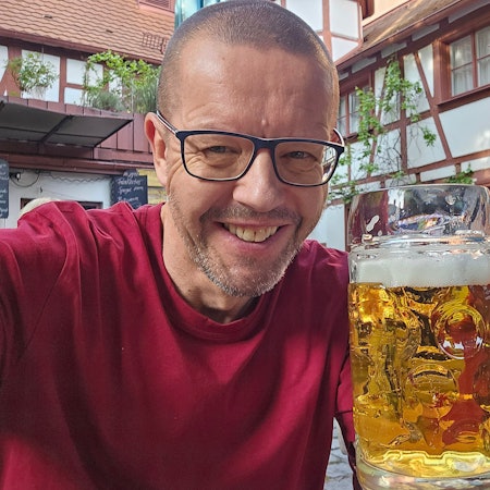 Auf dem Bild ist der Bierblogger Volker Quante zu sehen, der ein Glas Bier hält.