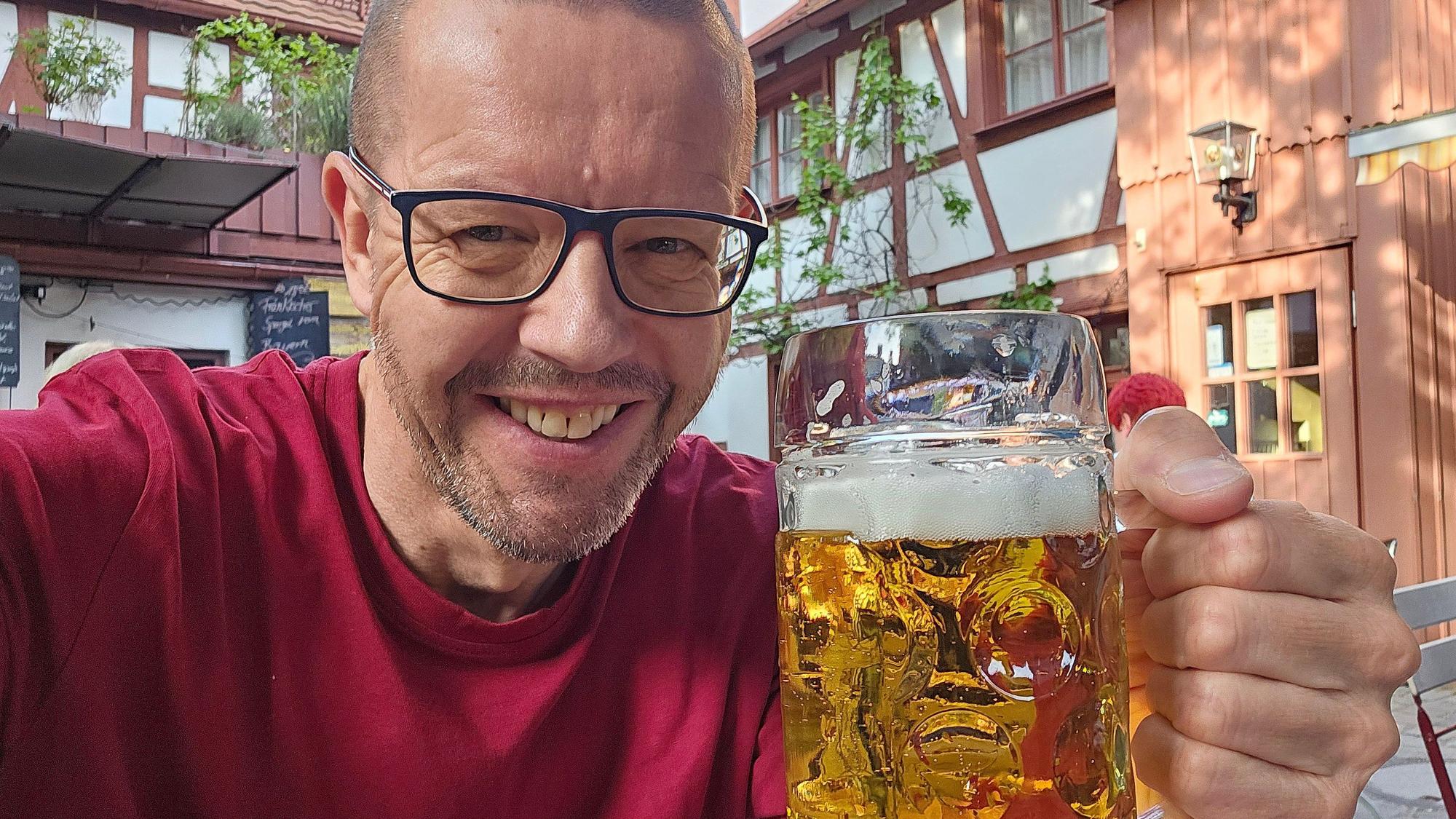 Auf dem Bild ist der Bierblogger Volker Quante zu sehen, der ein Glas Bier hält.