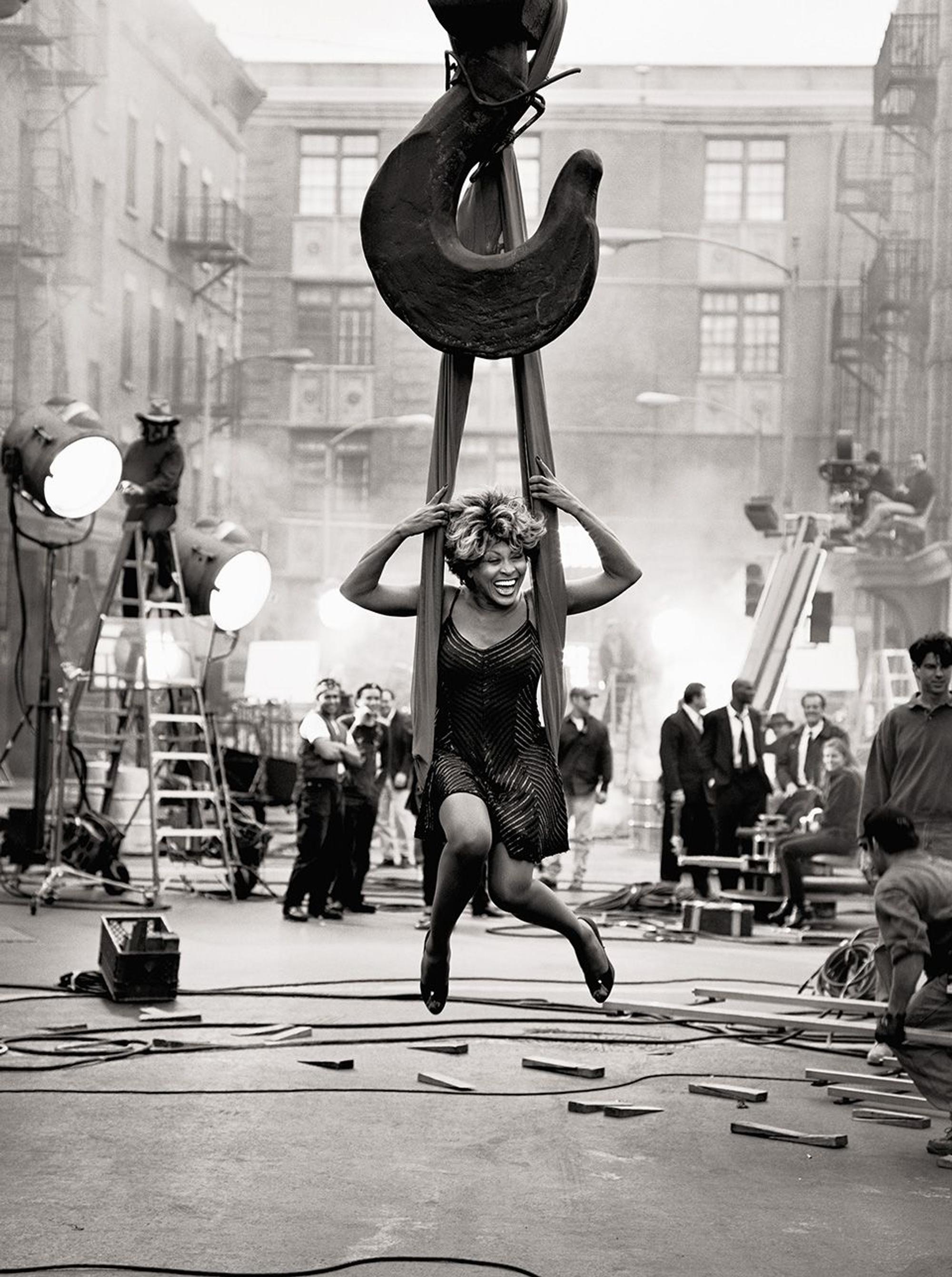 Tina Turner während der Dreharbeiten zum Musikvideo ihrer Single „Missing You“ auf dem Gelände der Paramount Studios, auf einem an einem schweren Haken befestigten Tuch schaukelnd.