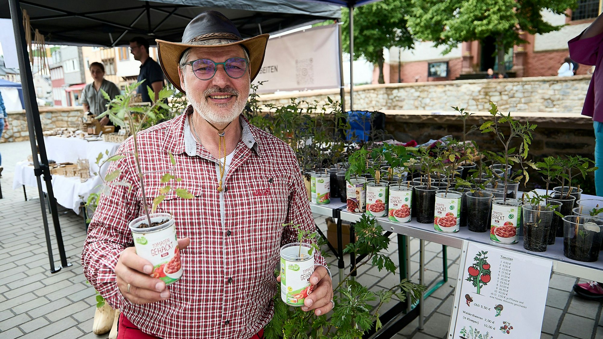 Mike Krüger hält zwei Pflanzen hoch.