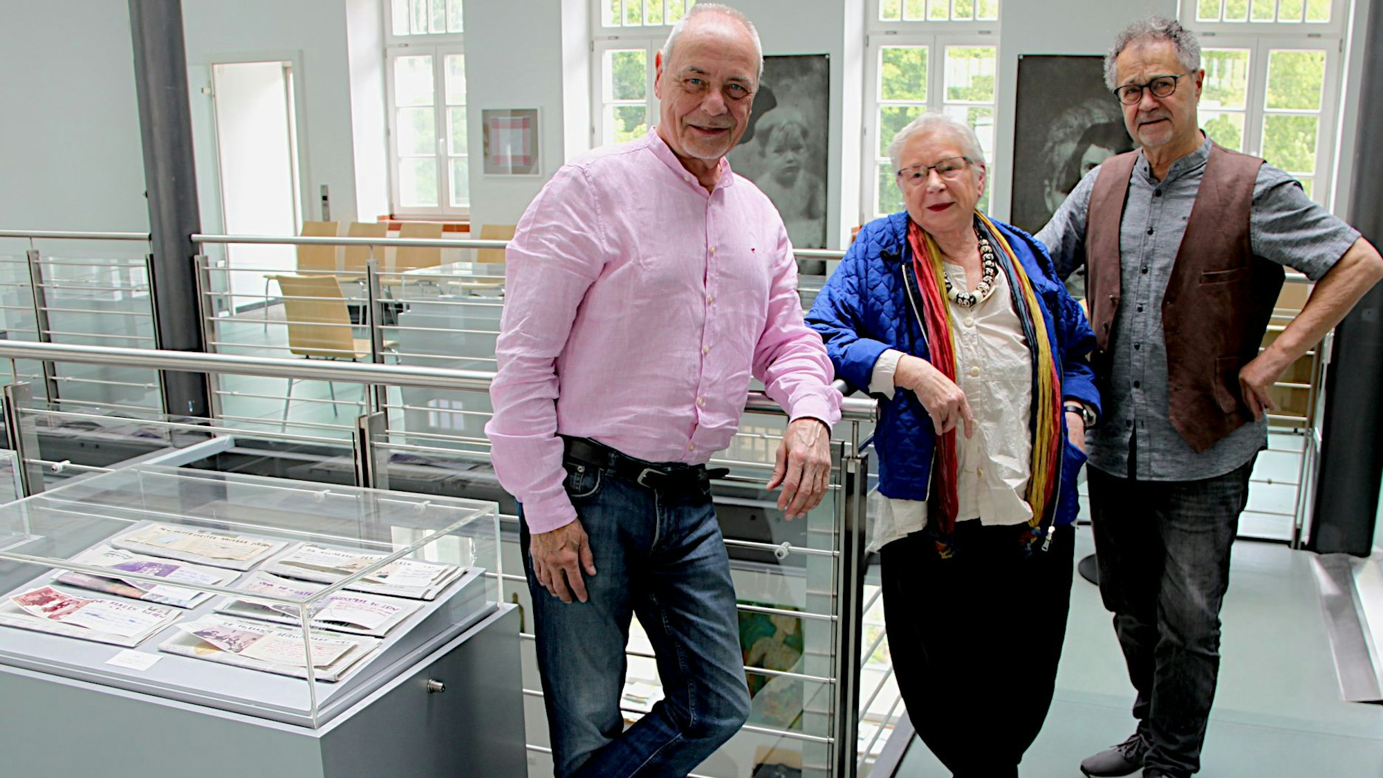 Die drei Vorstandsmitglieder lehnen sich an die Schaukästen in einem Ausstellungsraum des Kunst-Forums in der Alten Schule in Gemünd.
