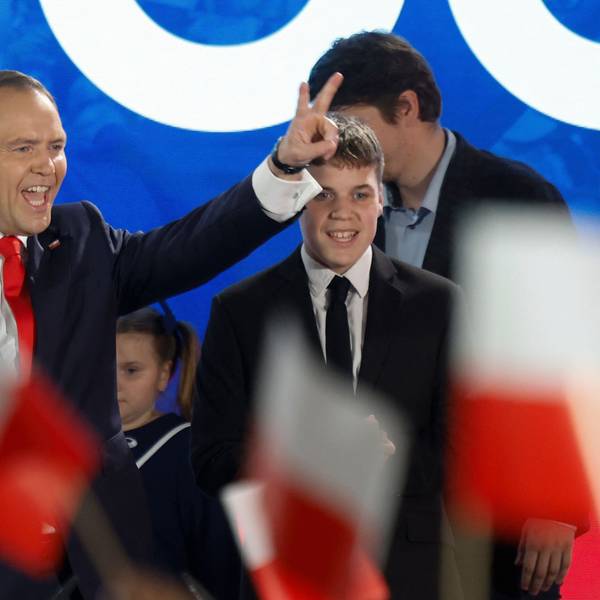Karol Nawrocki, candidate for the 2025 Polish presidential election supported by Poland's right-wing Law and Justice (PiS) party, flashes the victory sign in front of supporters as exit polls were announced on tv during their election night event at the Mala Warszawa Theatre in Warsaw, Poland, during the second round of the presidential elections on June 1, 2025. The centrist and nationalist candidates in Poland's presidential election on June 1 both claimed victory after an exit poll indicated they were neck and neck. (Photo by Wojtek RADWANSKI / AFP)