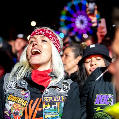 Das Bild zeigt eine Frau, die vor der Bühne steht und zu einem Song der Broilers mitsingt.