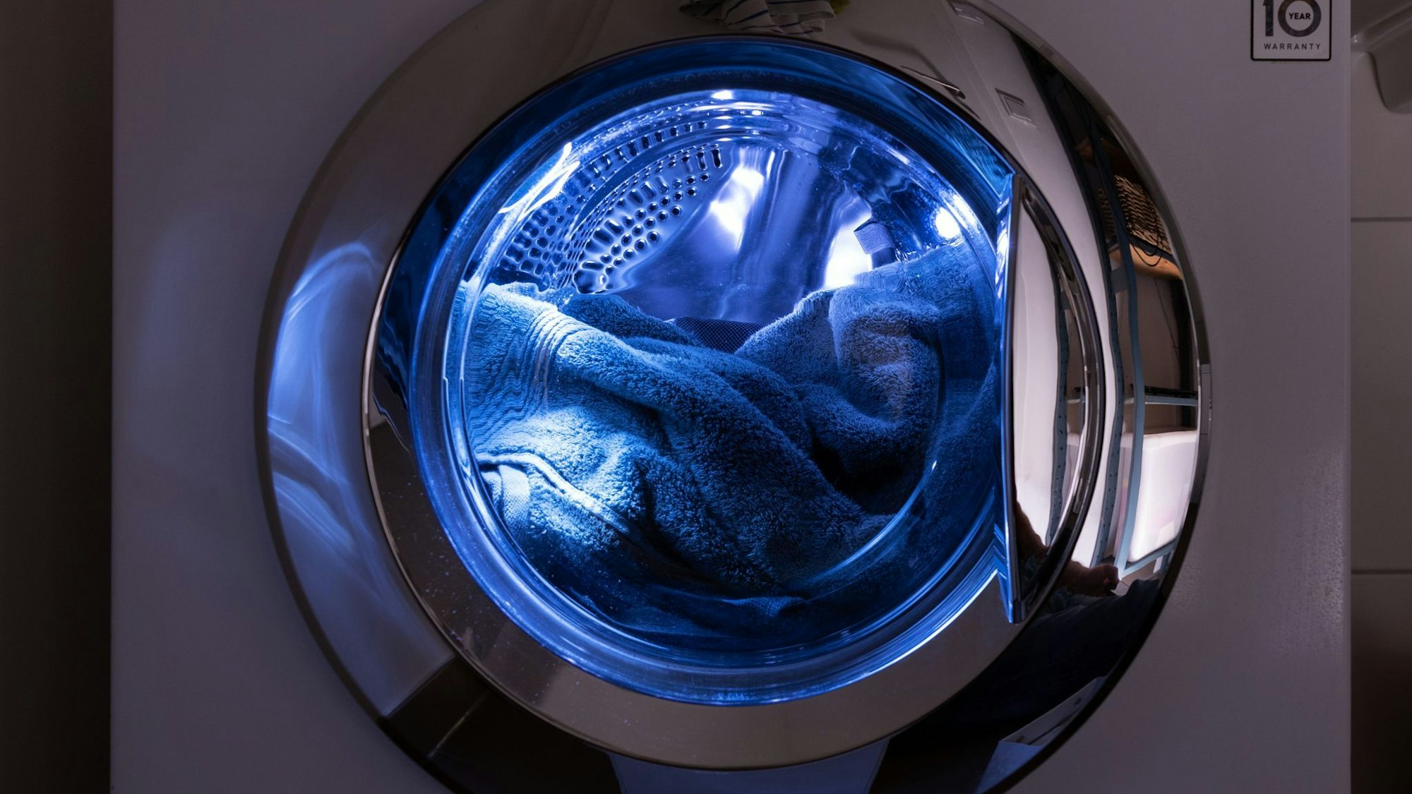 Eine offene Waschmaschine, in der Handtücher liegen.