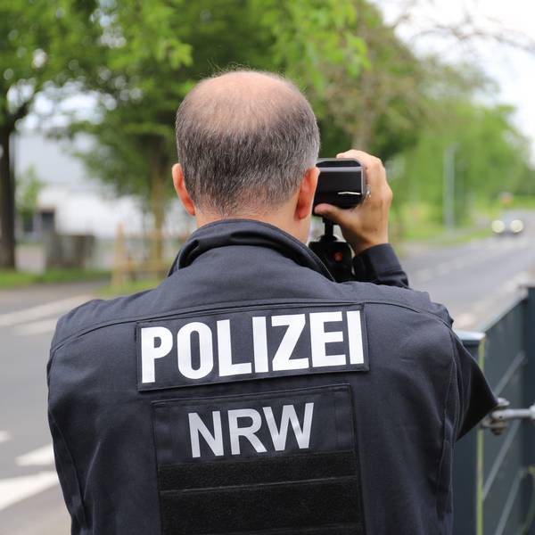 Ein Polizist misst mit einer Laserpistole die Geschwindigkeit von Fahrzeugen, die an der Kastanienschule vorbeifuhren.