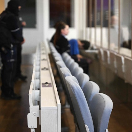 Im Gerichtssaal: Die Anklagebank mit einem Mann und einer Frau im Hintergrund ist zu sehen.