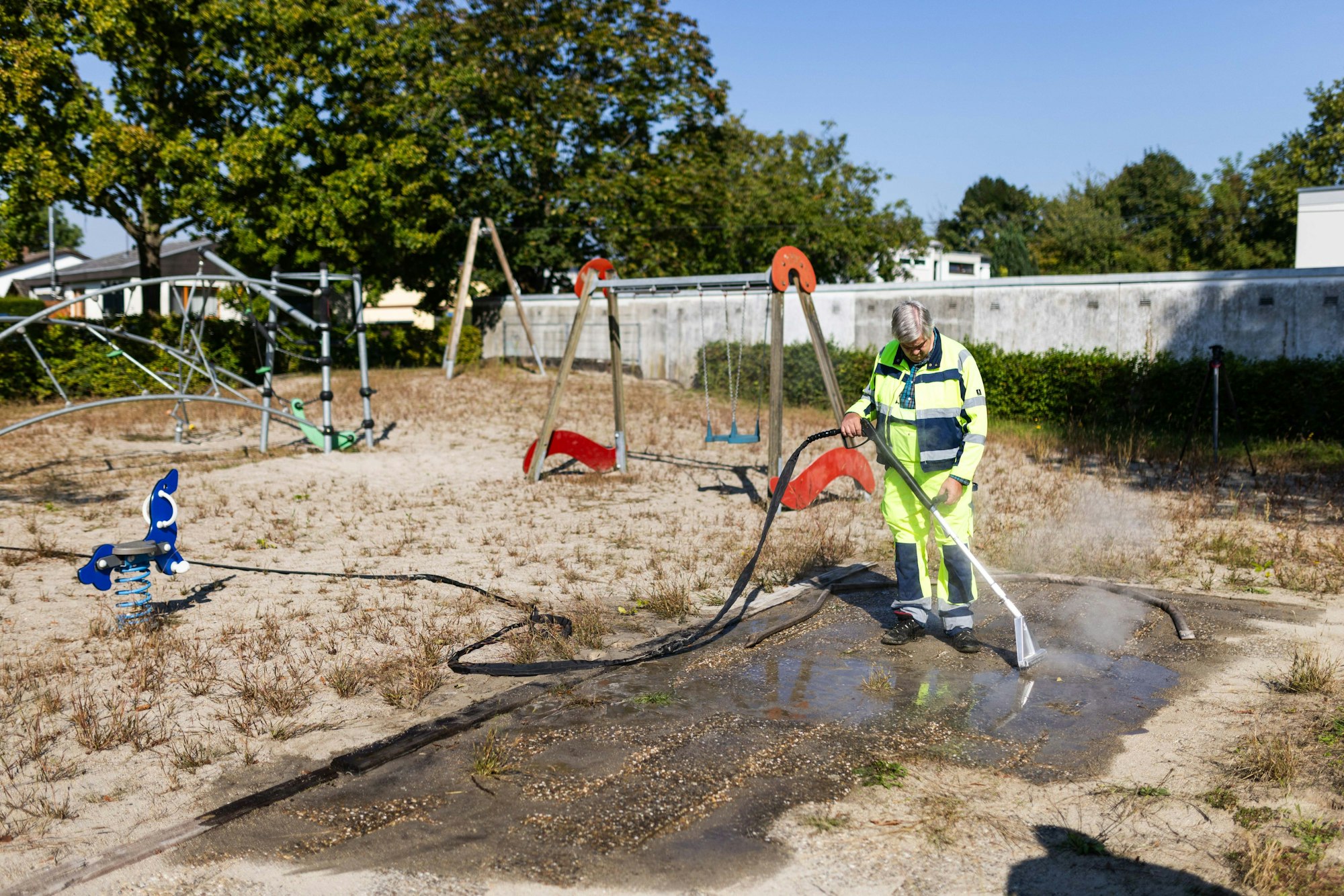 Ein Mitarbeiter der Stadt Kehl spritzt heißes Wasser in die Eingänge eines riesigen Ameisenbaus, der sich unter einem Spielplatz erstreckt.