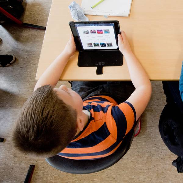Auf dem Bild sind zwei Schüler mit iPads zu sehen.