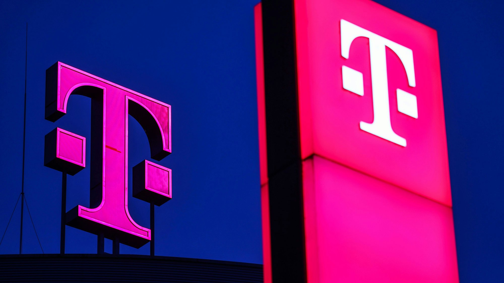 Logos der Deutsche Telekom leuchten auf der Zentrale des Unternehmens in Bonn.