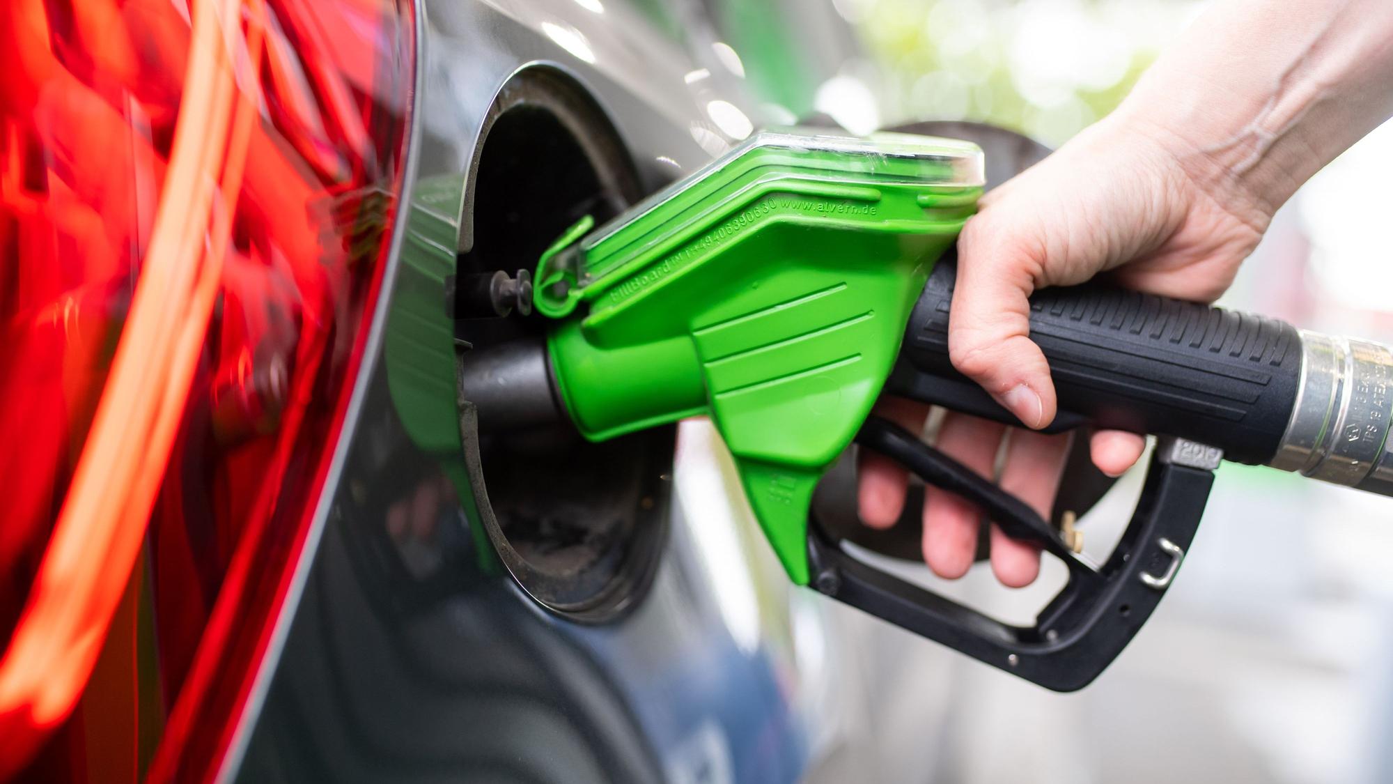 ARCHIV - 06.09.2020, Bayern, München: Eine Frau hält an einer Tankstelle an einer Zapfsäule eine Zapfpistole in der Hand und betankt ein Auto. (zu dpa: «Wo es sich auf dem Weg in die Pfingstferien günstig tankt») Foto: Sven Hoppe/dpa +++ dpa-Bildfunk +++