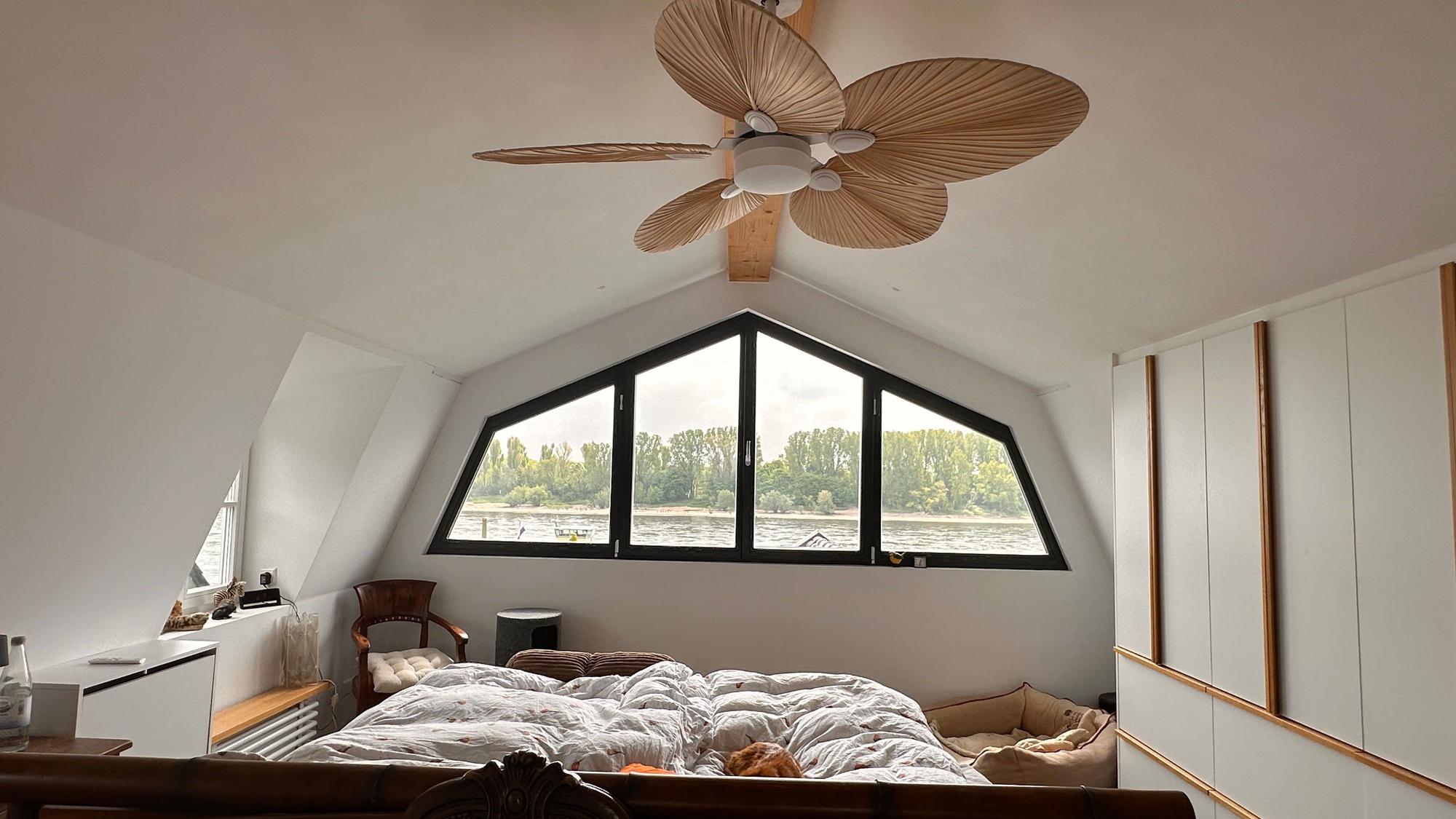 Ein Bett steht in einem Schlafzimmer, an der Decke ist ein Ventilator.