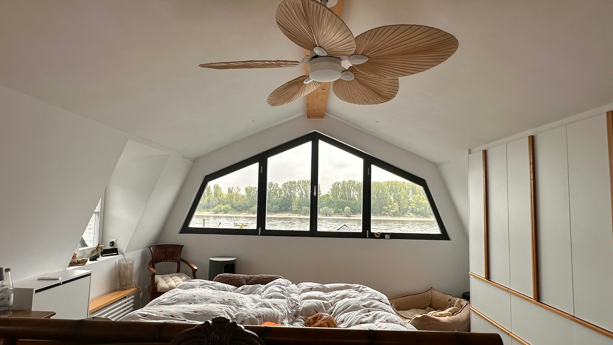 Ein Bett steht in einem Schlafzimmer, an der Decke ist ein Ventilator.