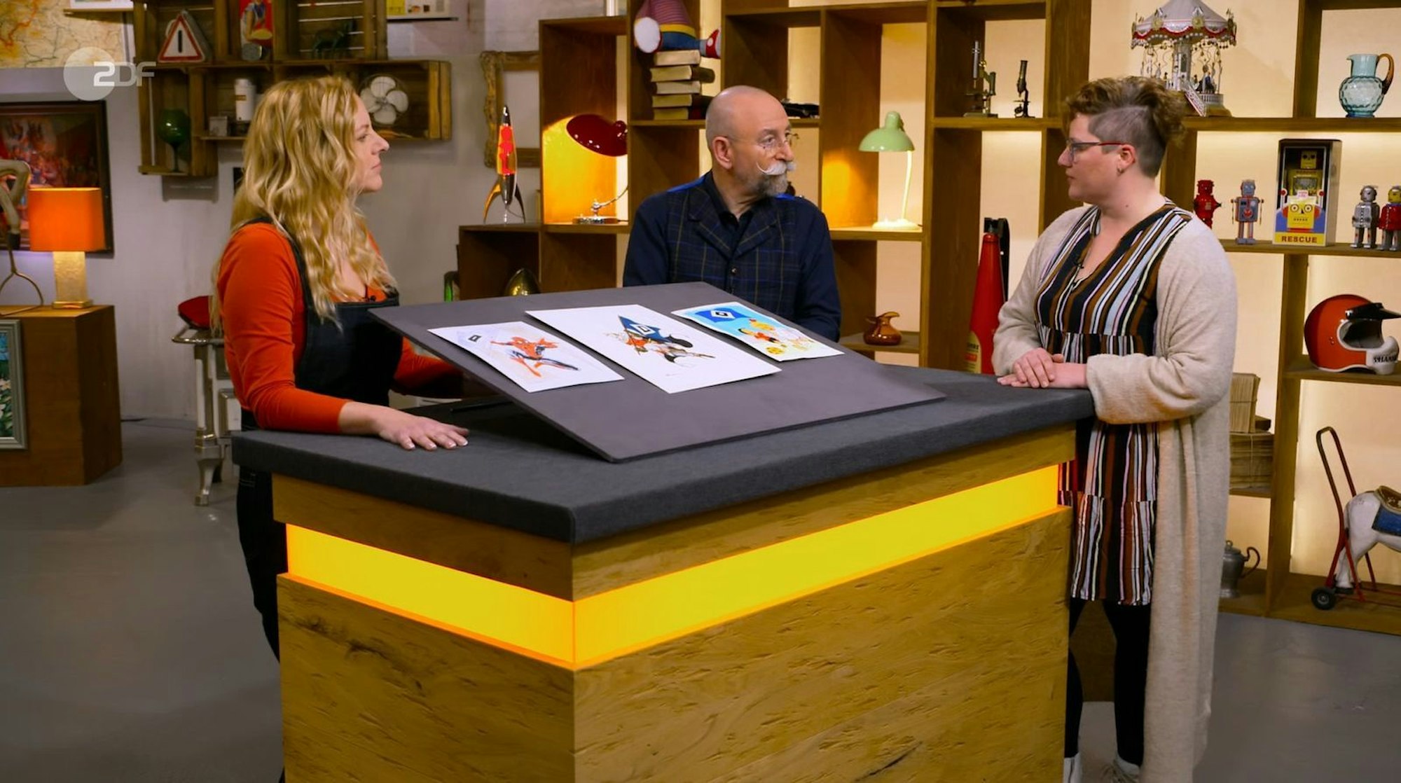 Die „Übeltäter“ waren drei Zeichnungen von drei verschiedenen Künstlern, genauer: Auftragsarbeiten, die Nadine (rechts) präsentierte. (Bild: ZDF)
