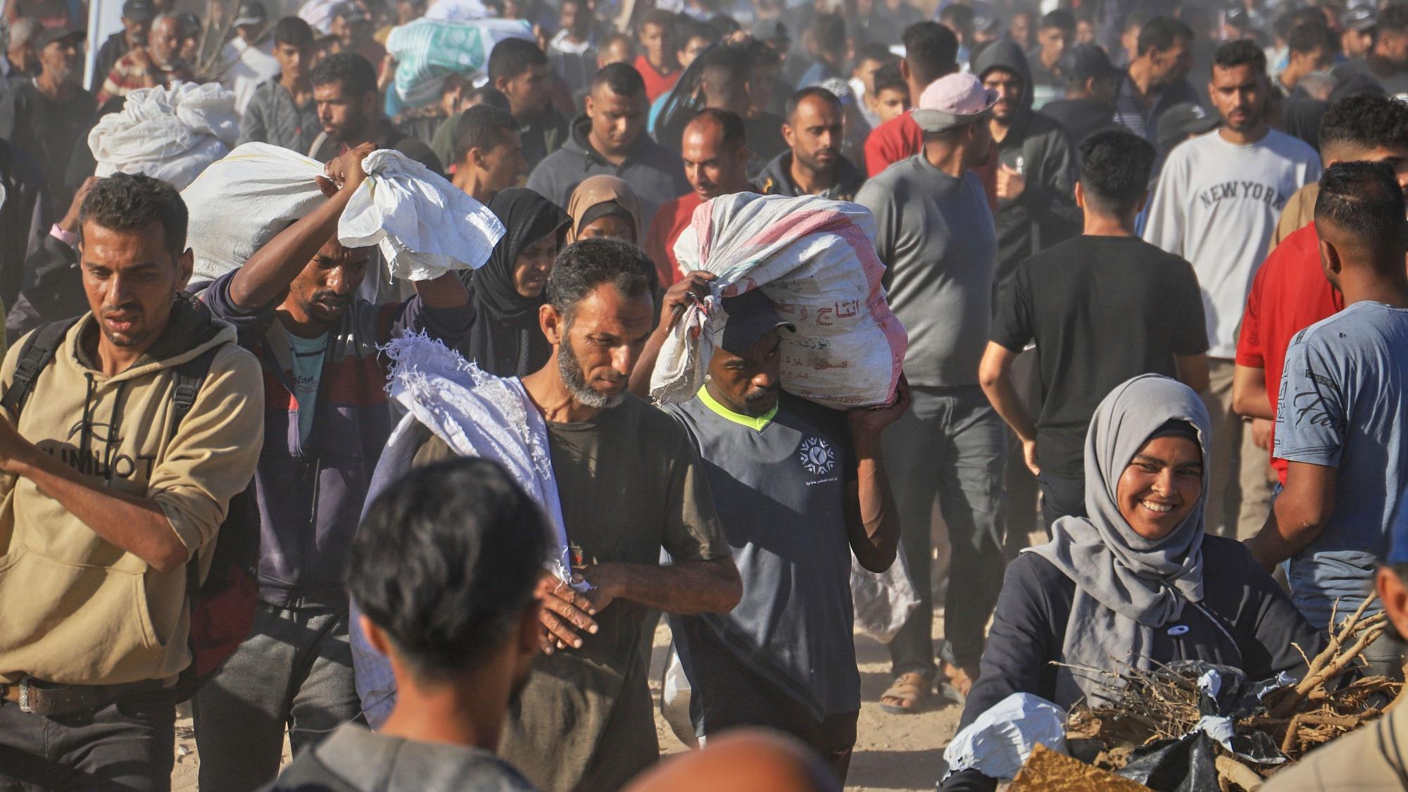 Palästinenser tragen in Rafah im südlichen Gazastreifen Kisten und Taschen mit Lebensmitteln und humanitären Hilfspaketen, die von der Gaza Humanitarian Foundation, einer von Israel anerkannten und von den USA unterstützten Organisation, geliefert wurden. (Archivbild)
