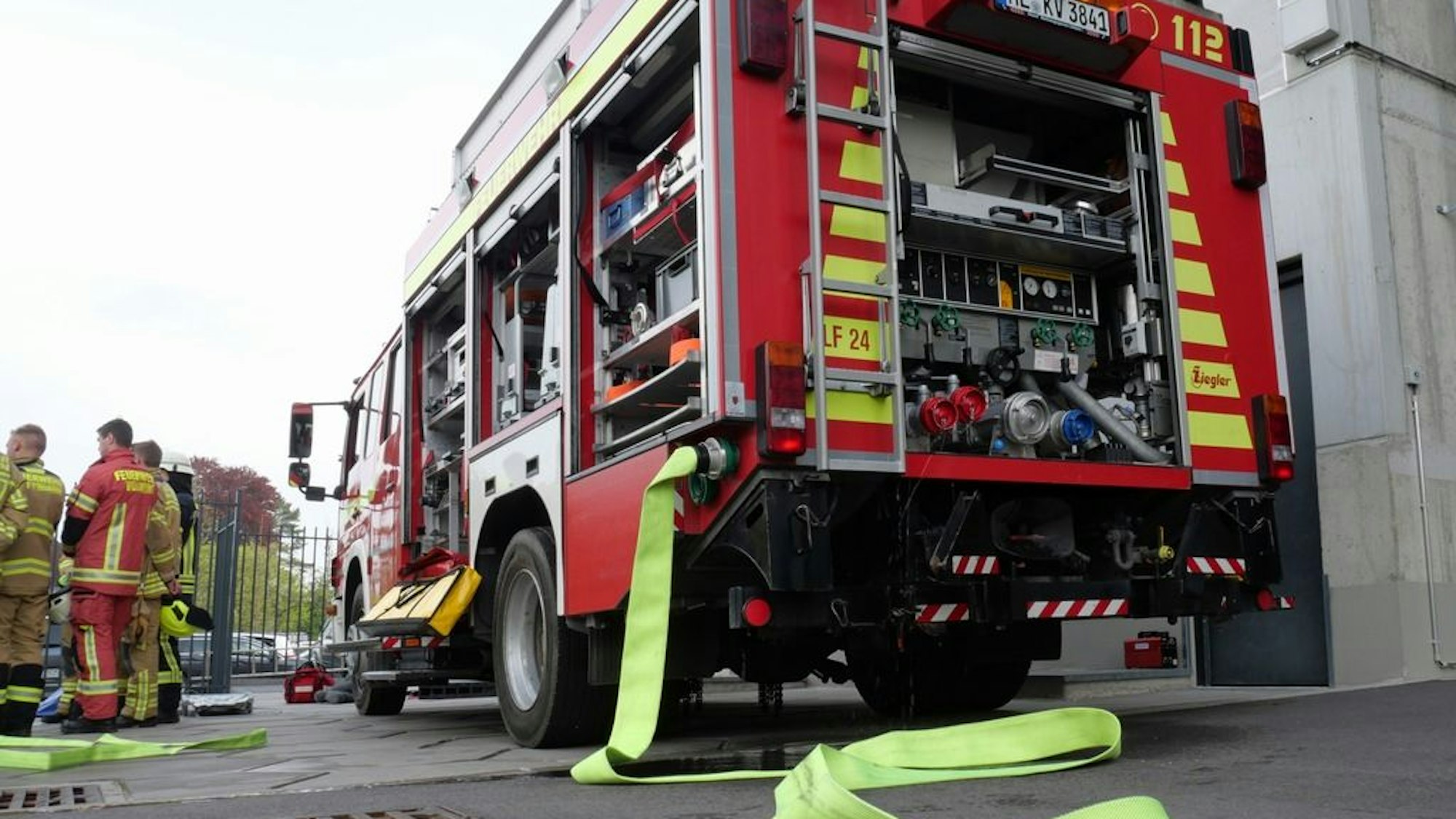 Feuerwehrwagen mit ausgerolltem Schlauch bei einem Löscheinsatz. Die Polizei ermittelt wegen vorsätzlicher Brandstiftung in Wülfrath.