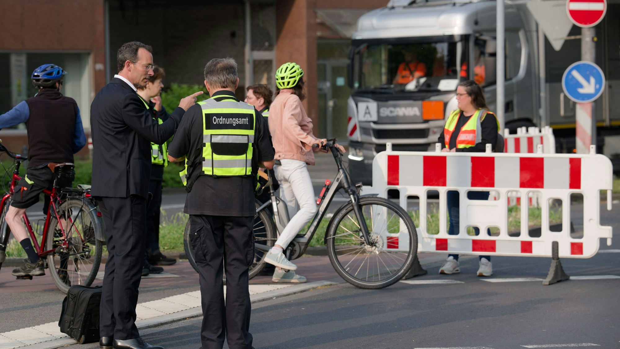 Mitarbeiter des Ordnungsamtes erklären Passanten die Straßensperrungen wegen einer Bombenentschärfung.