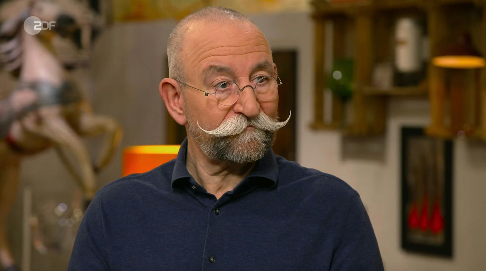 „Hattest du Langeweile, hast du etwas gemalt?“, fragte Horst Lichter Expertin Annika Raßbach ganz unbedarft, als er das vollgekritzelte „Zettelchen“ auf dem Pult liegen sah. (Bild: ZDF)