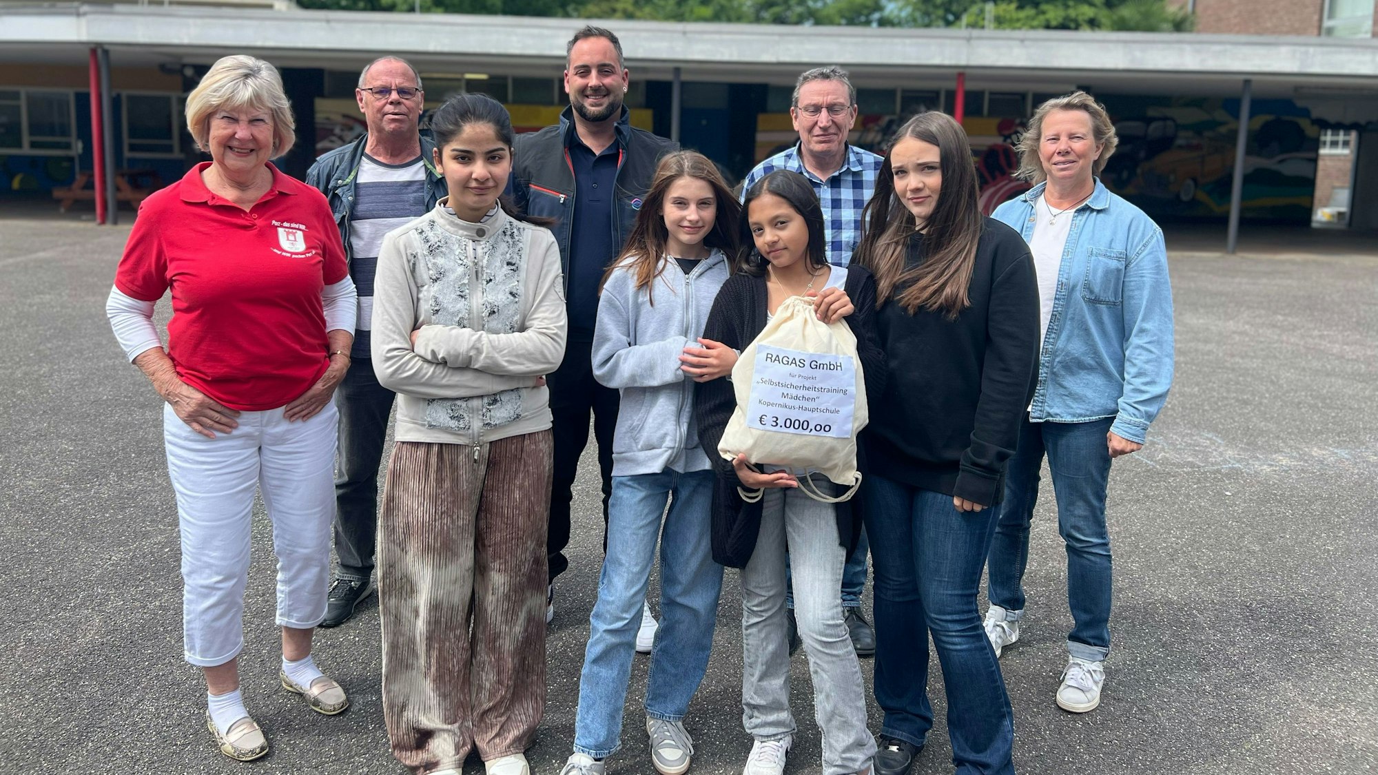 Die Spende nehmen Doreen, Isabella, Ornella und Angelina (vorne v.l.) für ihr Selbstsicherheitstraining für Mädchen an der Kopernikushauptschule im Beisein von Anita Mirche, Heiko Hillers, Nikolai Schieren, Michael Neuser und Anja Derksen (hinten v.l.) entgegen.