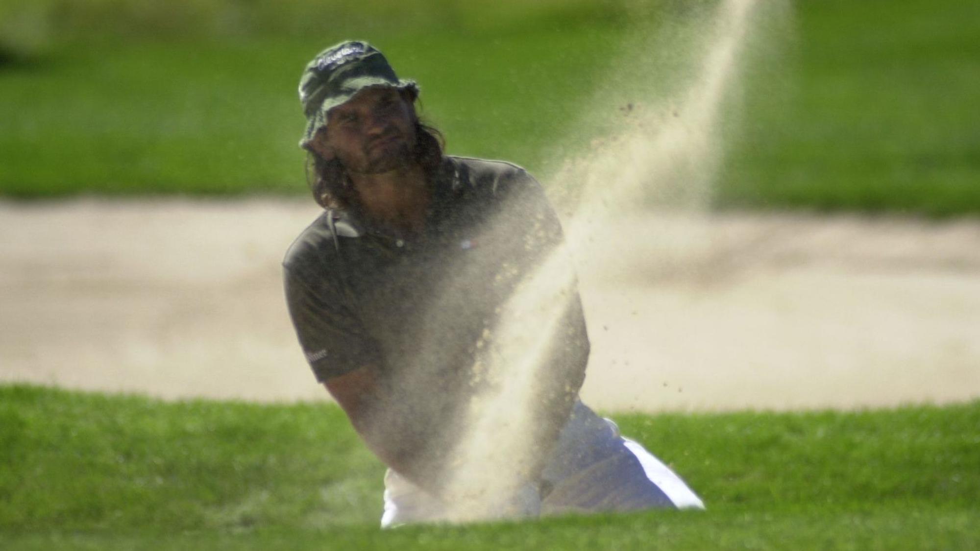 Ein Golfspieler schlägt einen Ball.