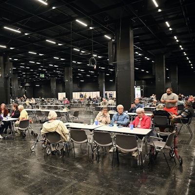 Menschen warten in der Anlaufstelle der Stadt Köln in einer Messehalle auf da Ende der Bombenentschärfung.