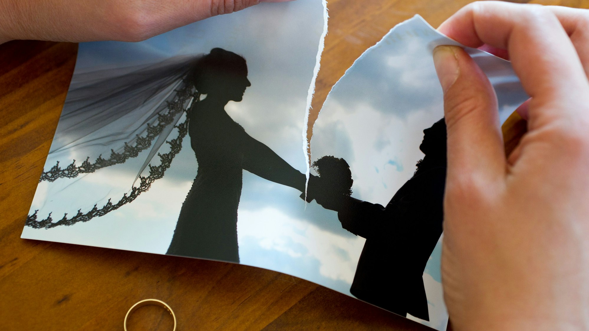 Eine Frau zerreißt ihr Hochzeitsfoto. (Symbolfoto)