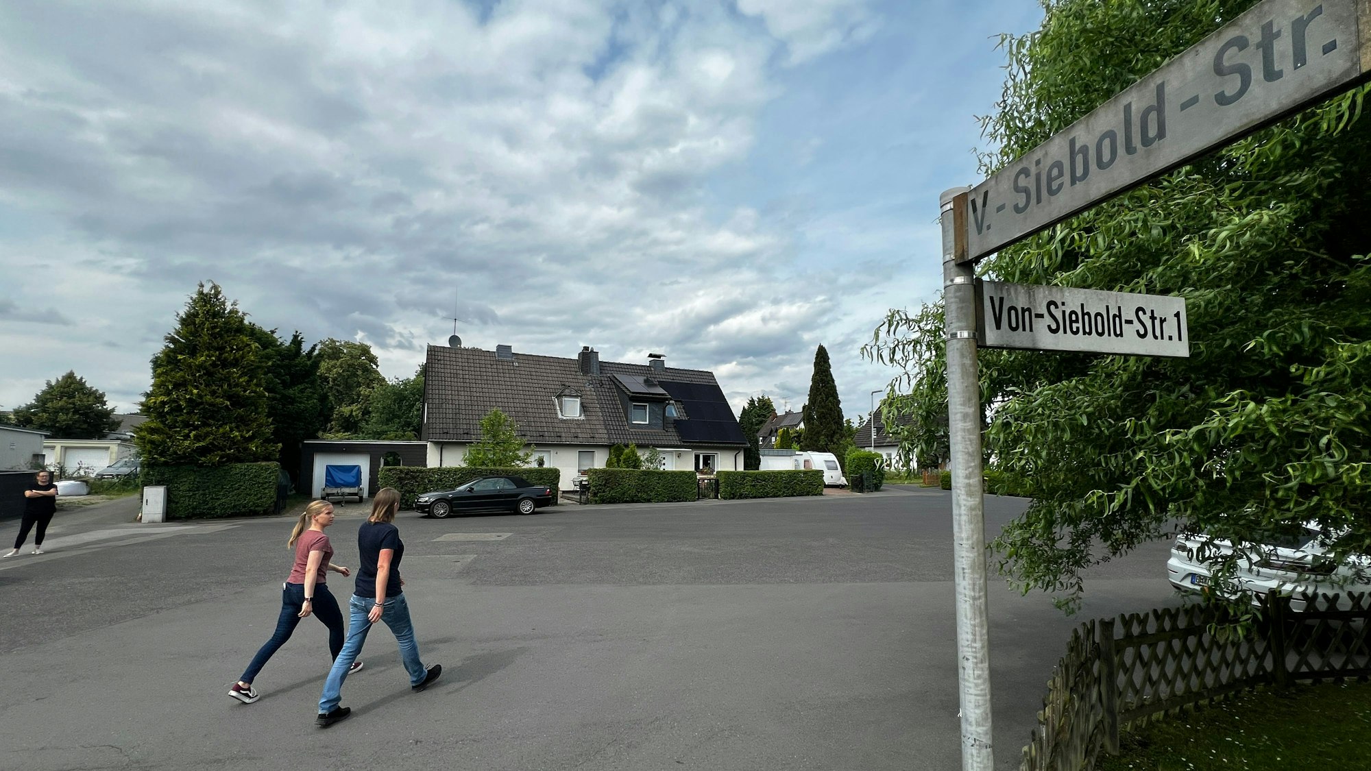 Zwei Passanten gehen über einen Platz.