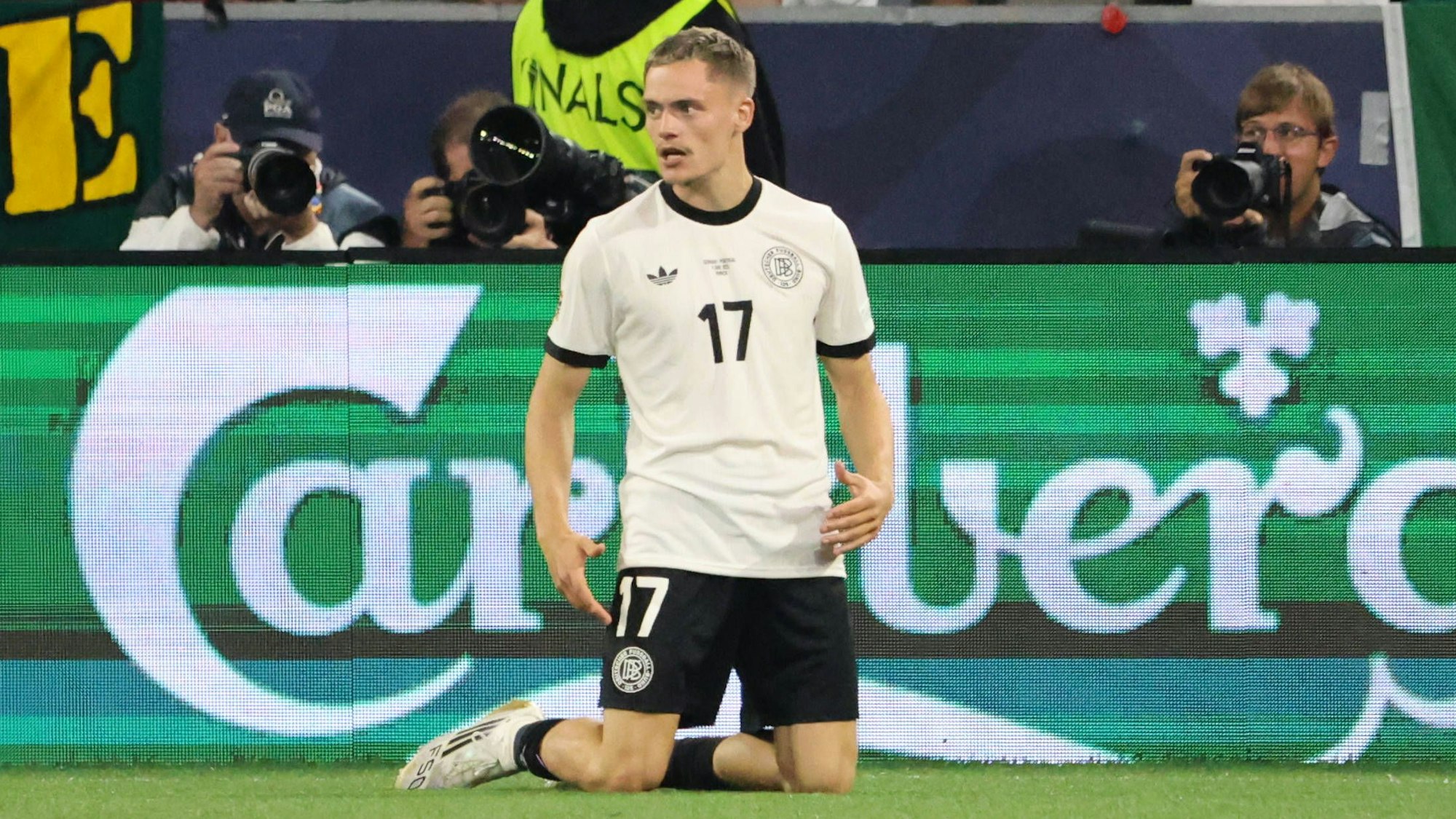 Florian Wirtz kniet auf dem Rasen in München.