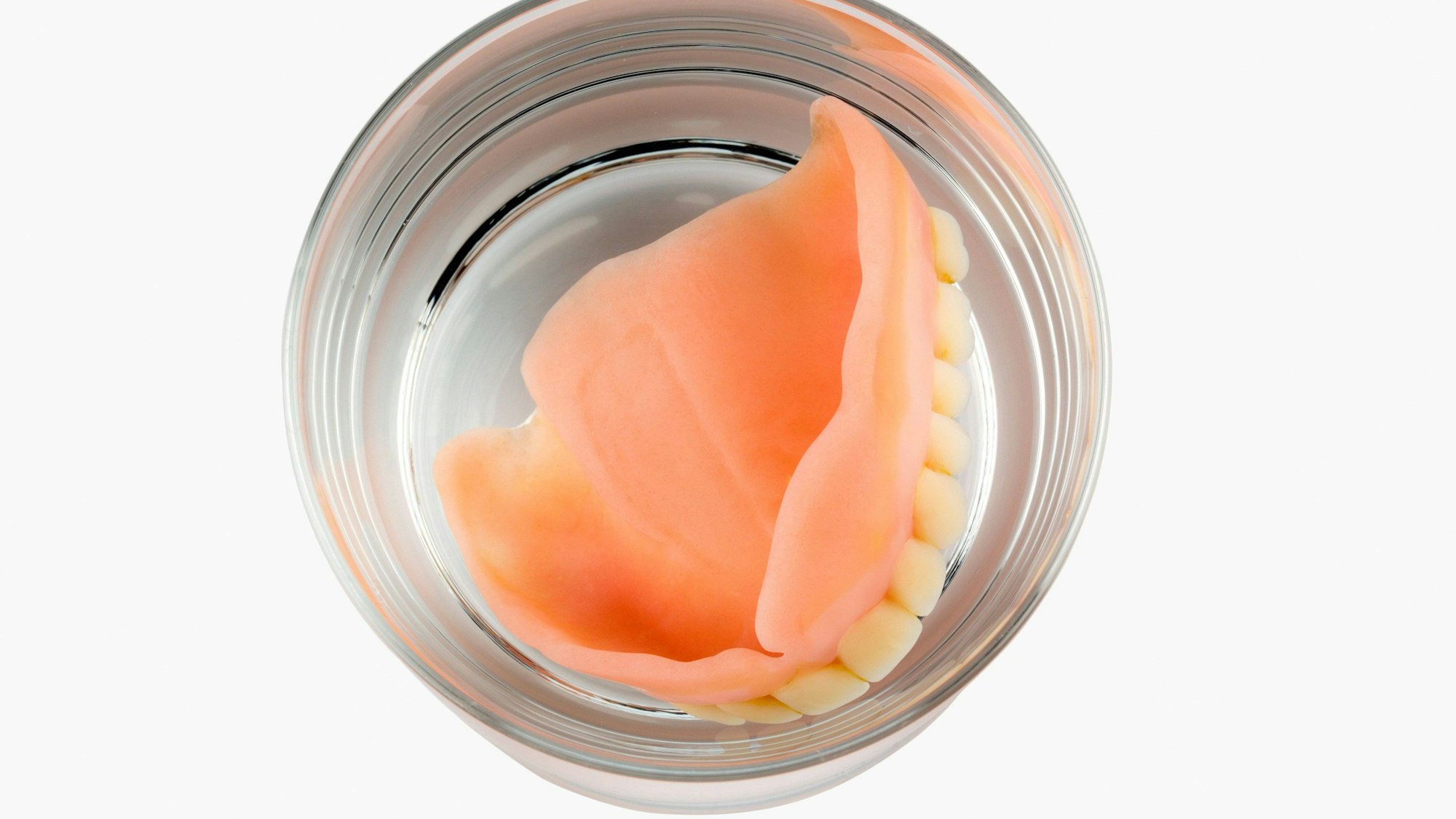 Zahnprothese im Wasserglas.