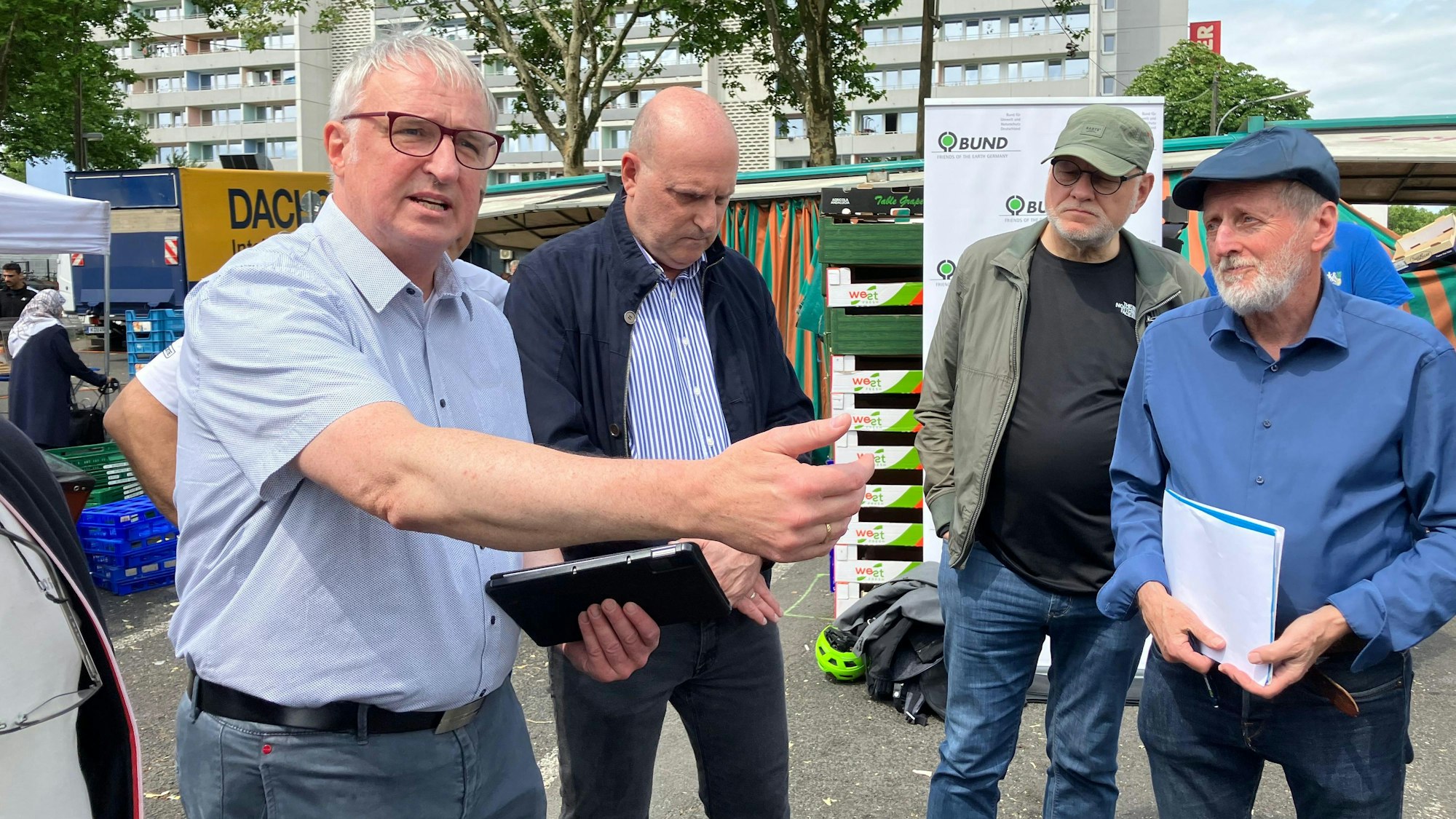Michael Rieke, Sprecher der Interessengemeinschaft Kölner Großmarkt (v.l.), Pablo Steinberg der AG Frischezentrum vom BUND Köln, Jörg Frank vom BUND und Helmut Röscheisen, Kölner BUND-Vorstandsmitglied stellen auf dem Wochenmarkt auf dem Rochusplatz ihre Pläne für ein Frischezentrum vor.