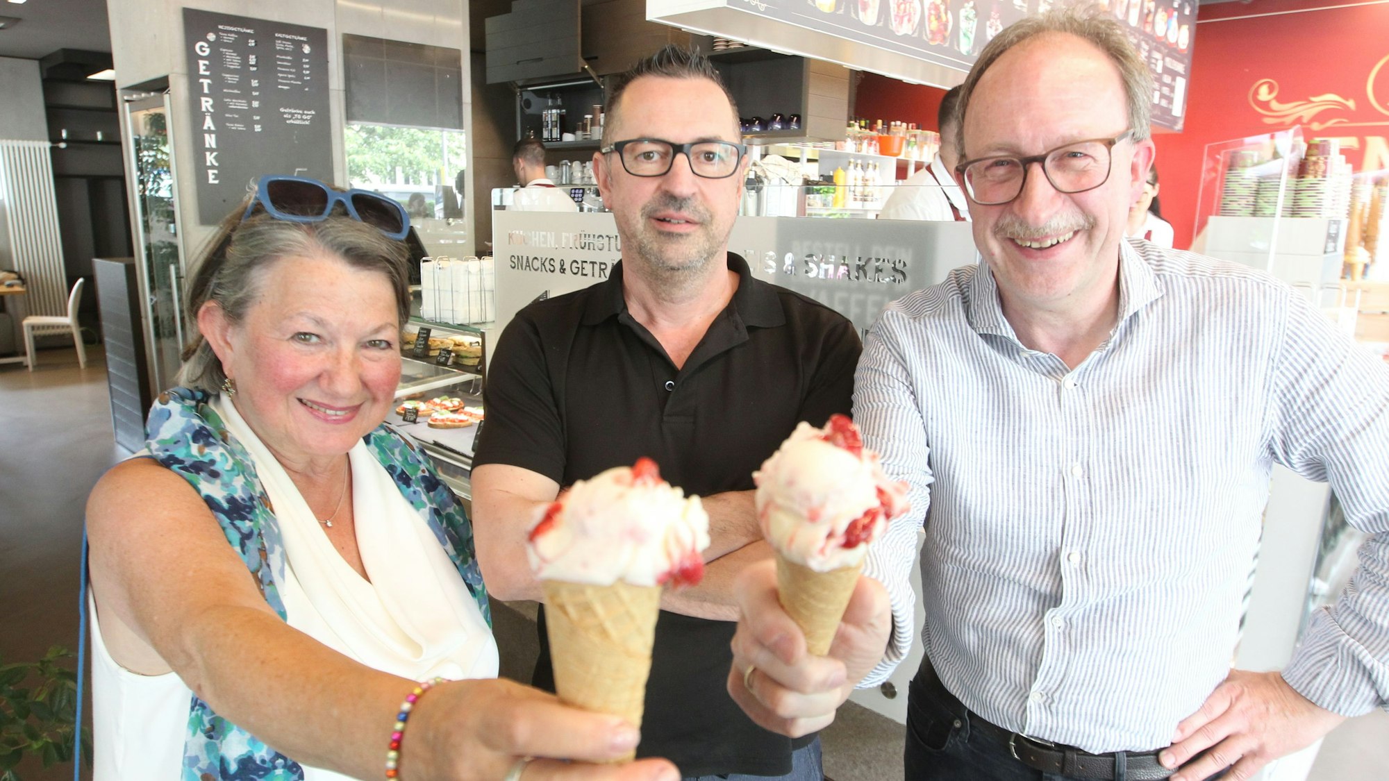 Das Hennef-Eis in den Stadtfarben Rot und Weiß ist da: Massimo Remor (Mitte) hat es kreiert. Andrea Hoppen-Weiss und Thomas Wallau kosten es.
