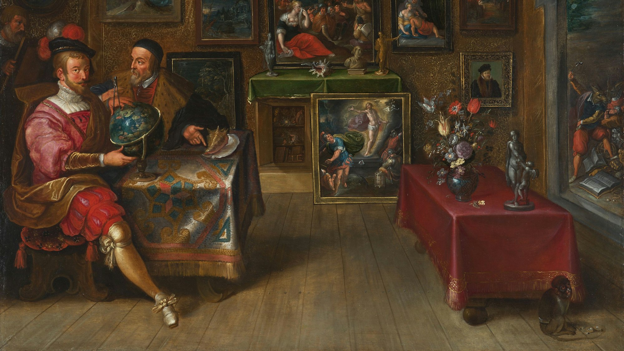 Zwei Gelehrte sitzen vor einer Bilderwand.