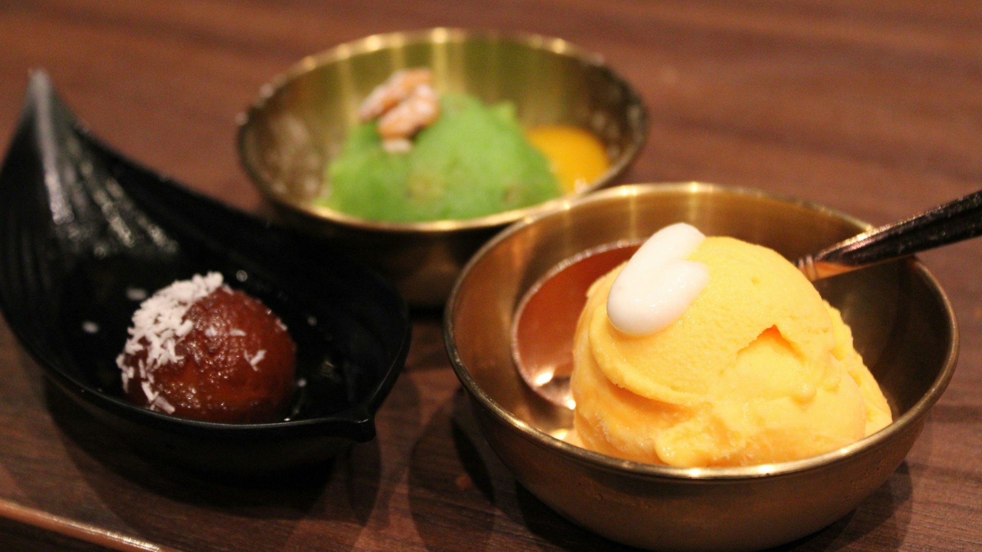 Den beliebten Mango-Lassi gibt es auch als Eis, neben traditionell indischen Desserts.