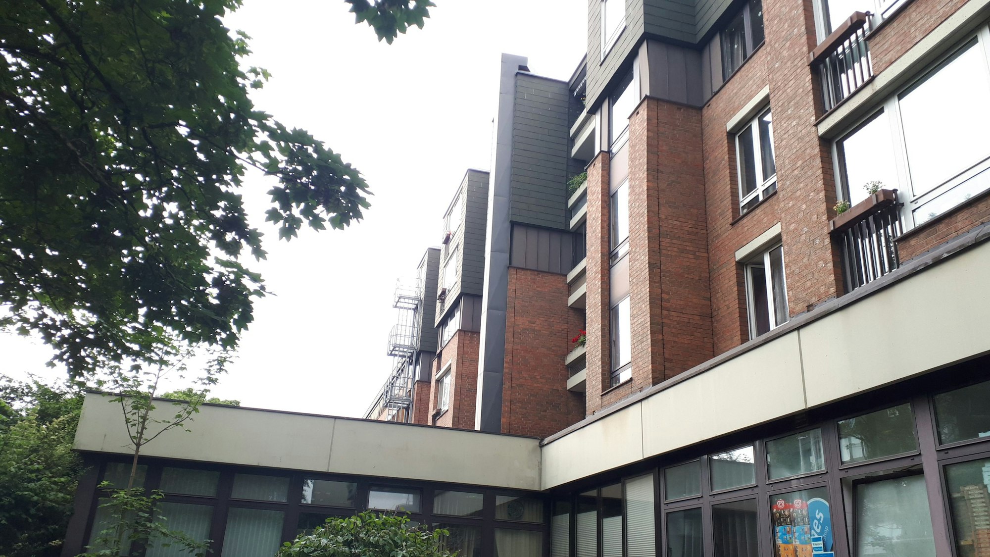 Zu sehen ist ein Kaminschacht (in Silber / Grau), der in einem Wohnpark für einen Abtransport der Küchenluft nach oben sorgt.