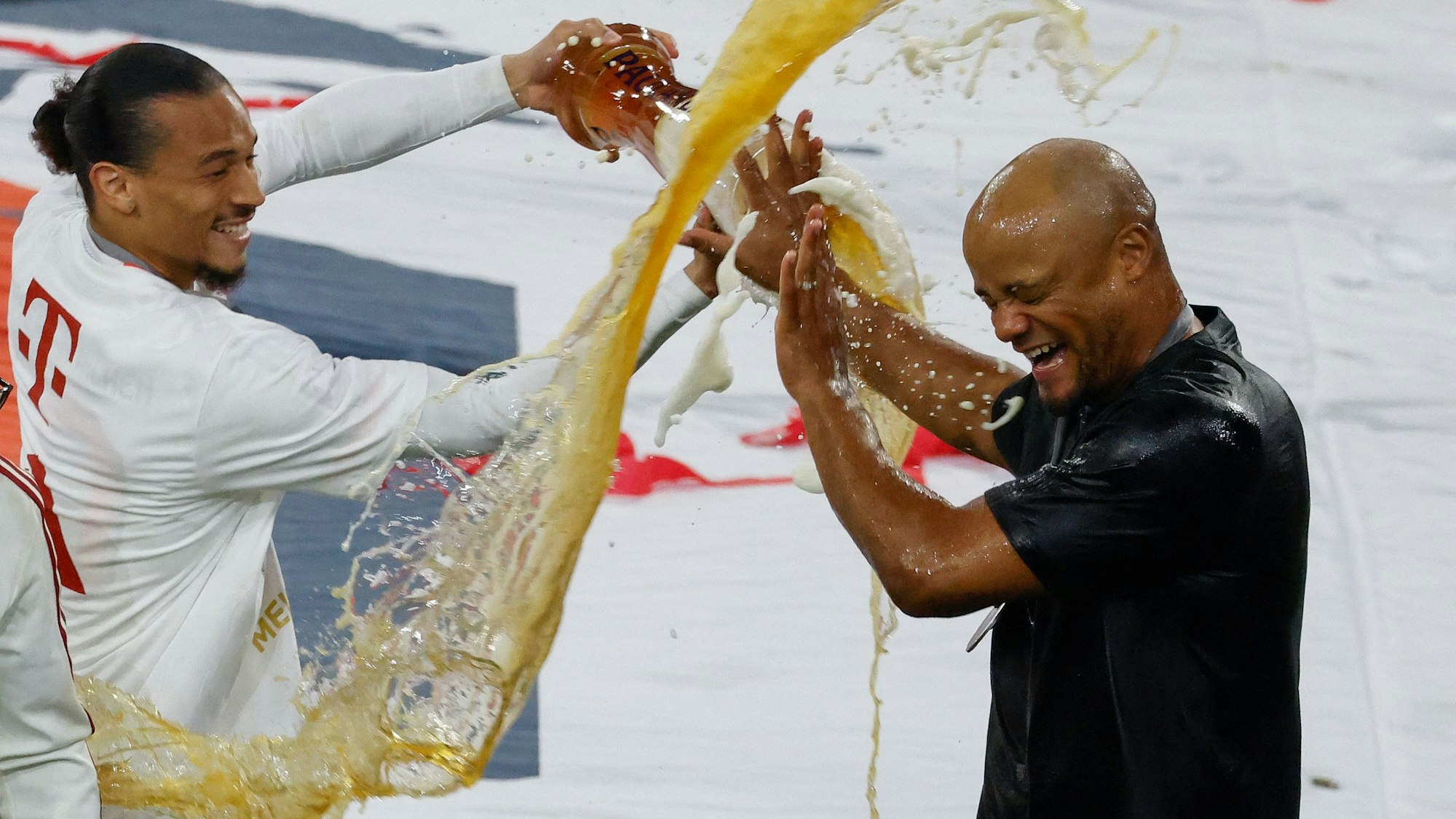Vincent Kompany und Leroy Sané verpassen sich gegenseitig eine Bierdusche bei der Meisterfeier.