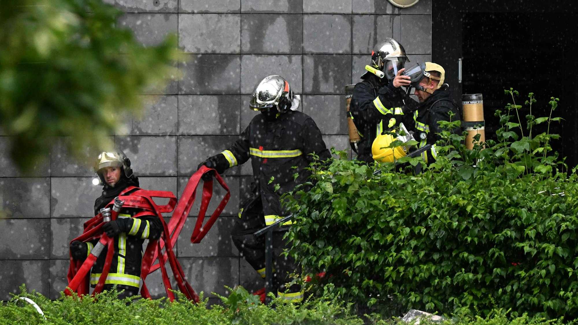 Feuerwehrleute verlassen ein Gebäude, nachdem sie ein Feuer gelöscht haben, das in der Nacht zum 6. Juni 2025 in einem Wohnhaus in Reims ausgebrochen war.