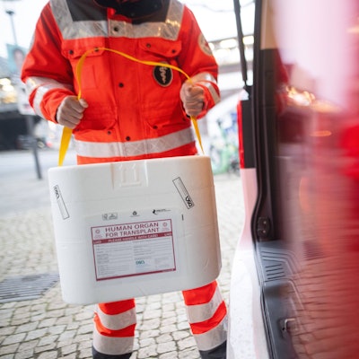Ein Mitarbeiter des DRK stellt eine Kühlbox für eine Organspende in einen Transporter des Deutschen Roten Kreuzes. (gestellte Szene)
