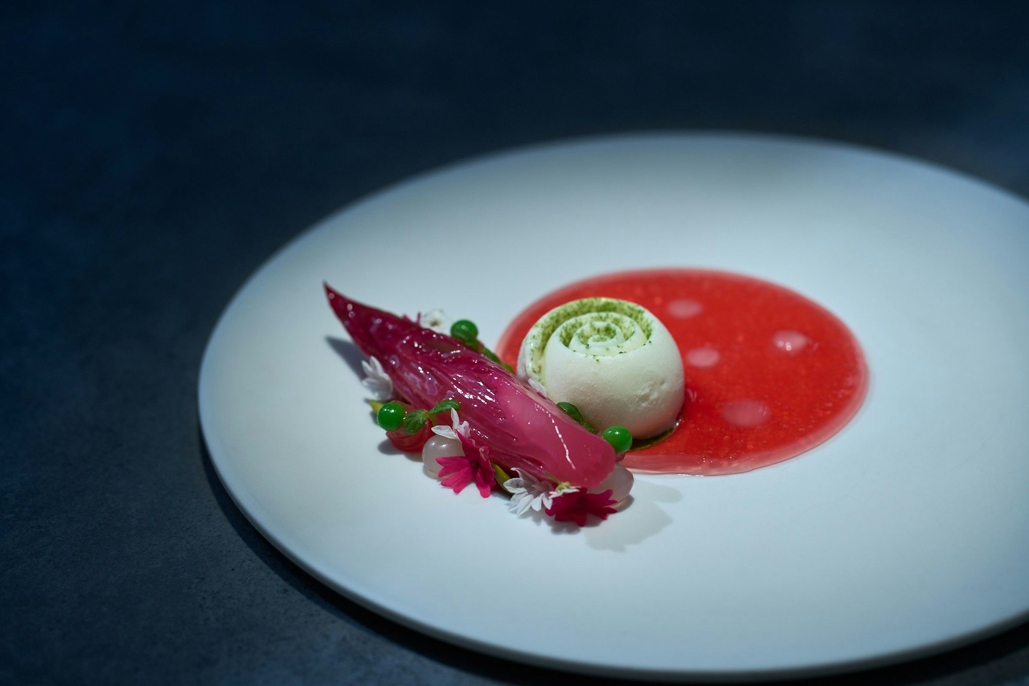 Aufwändiges Arrangement auf einem Teller in Rottönen.