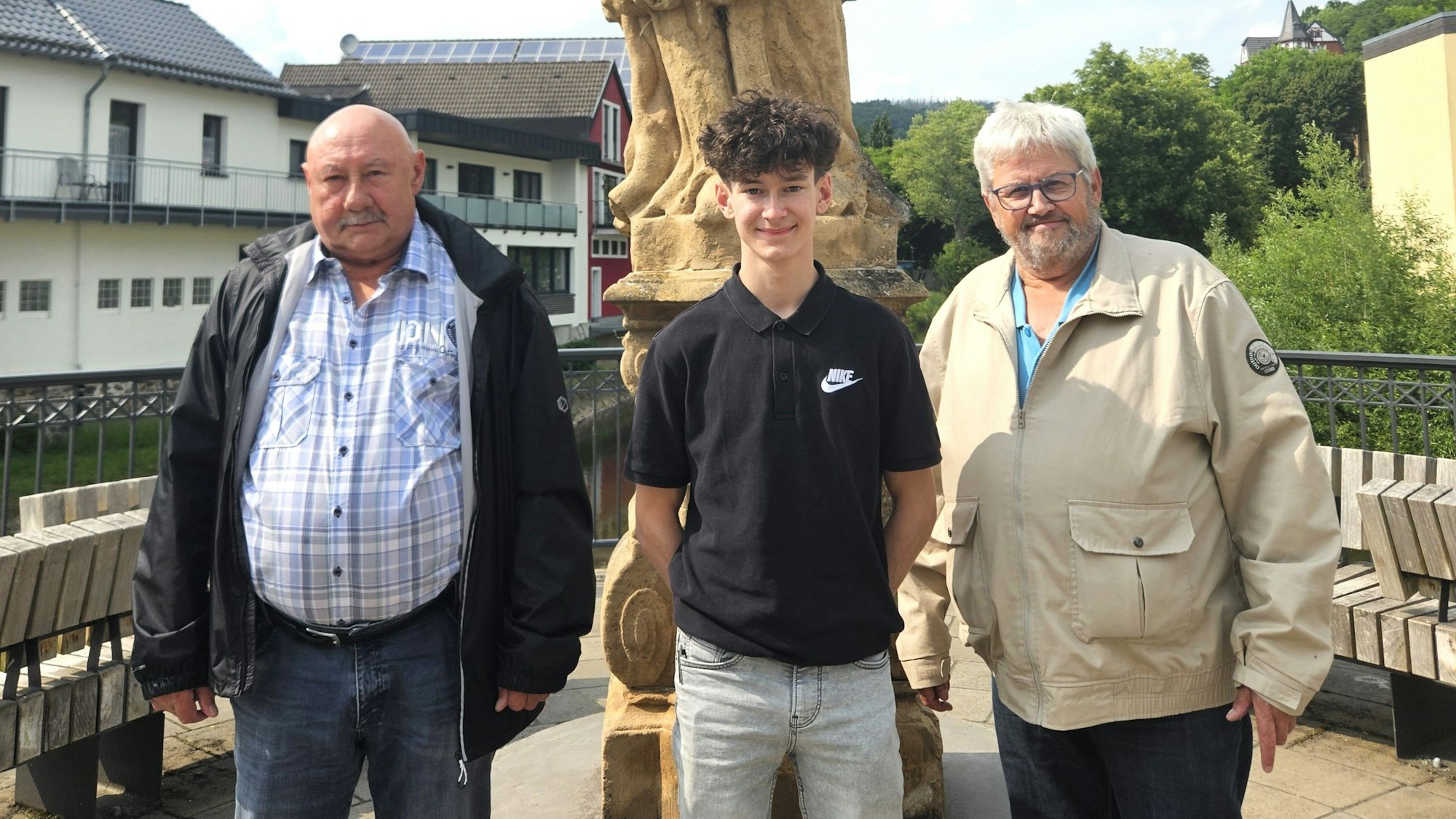 Franz-Albert Heinen, Christian Baran und Wolfgang Pommer (v.l.) stehen vor der Nepomuk-Statue am Zusammenfluss von Urft und Olef.