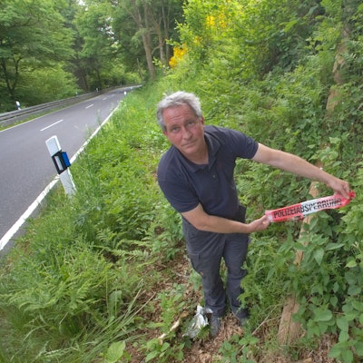 In einem Graben bei Waldbröl-Spurkenbach hat Wastl Roth-Seefrid einen gefällten Leitungsmast entdeckt, daran hängt ein Flatterband von der Polizei.