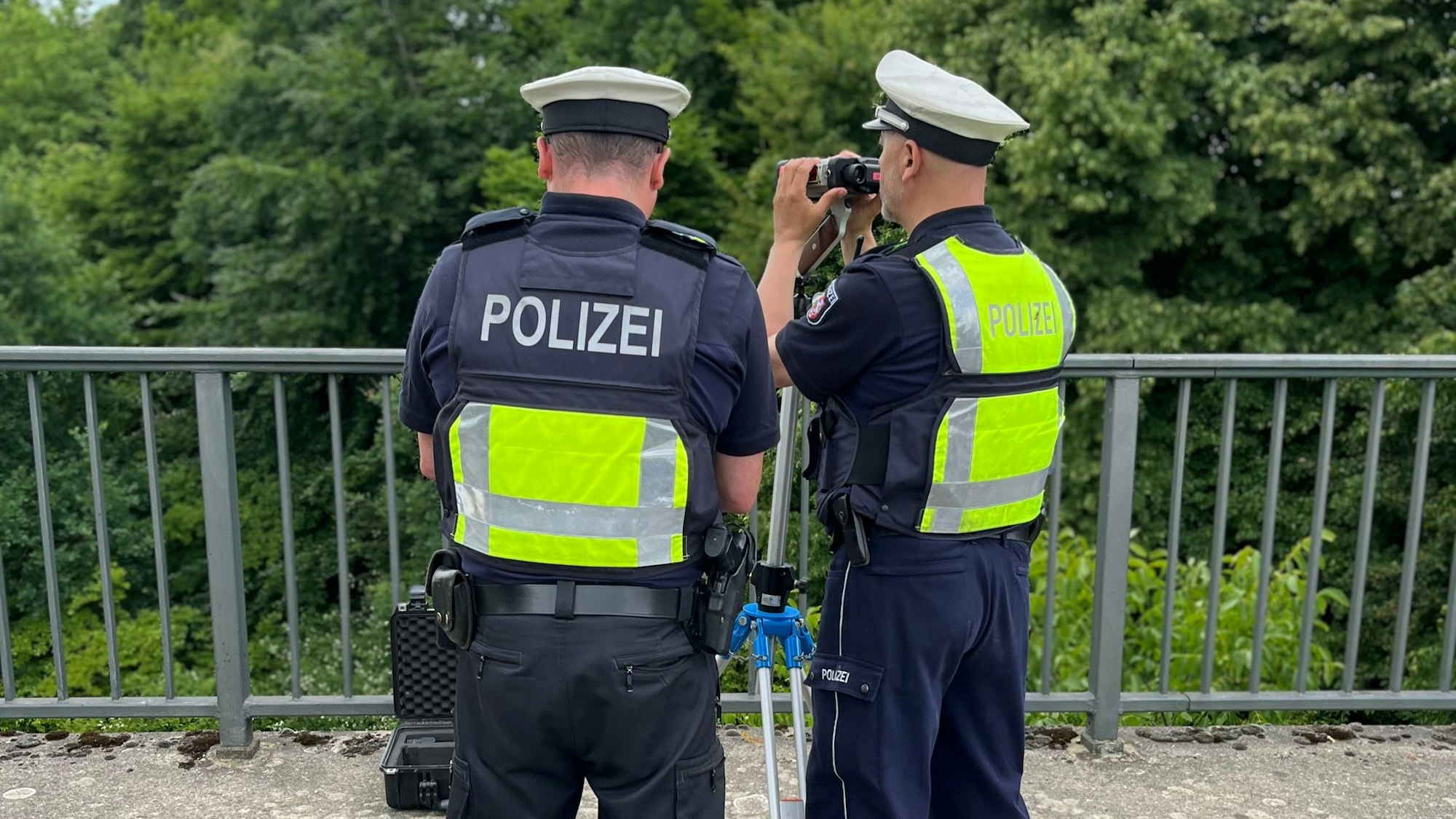 Von einer Brücke beobachten Polizeibeamte den Verkehr auf der Bundesstraße.
