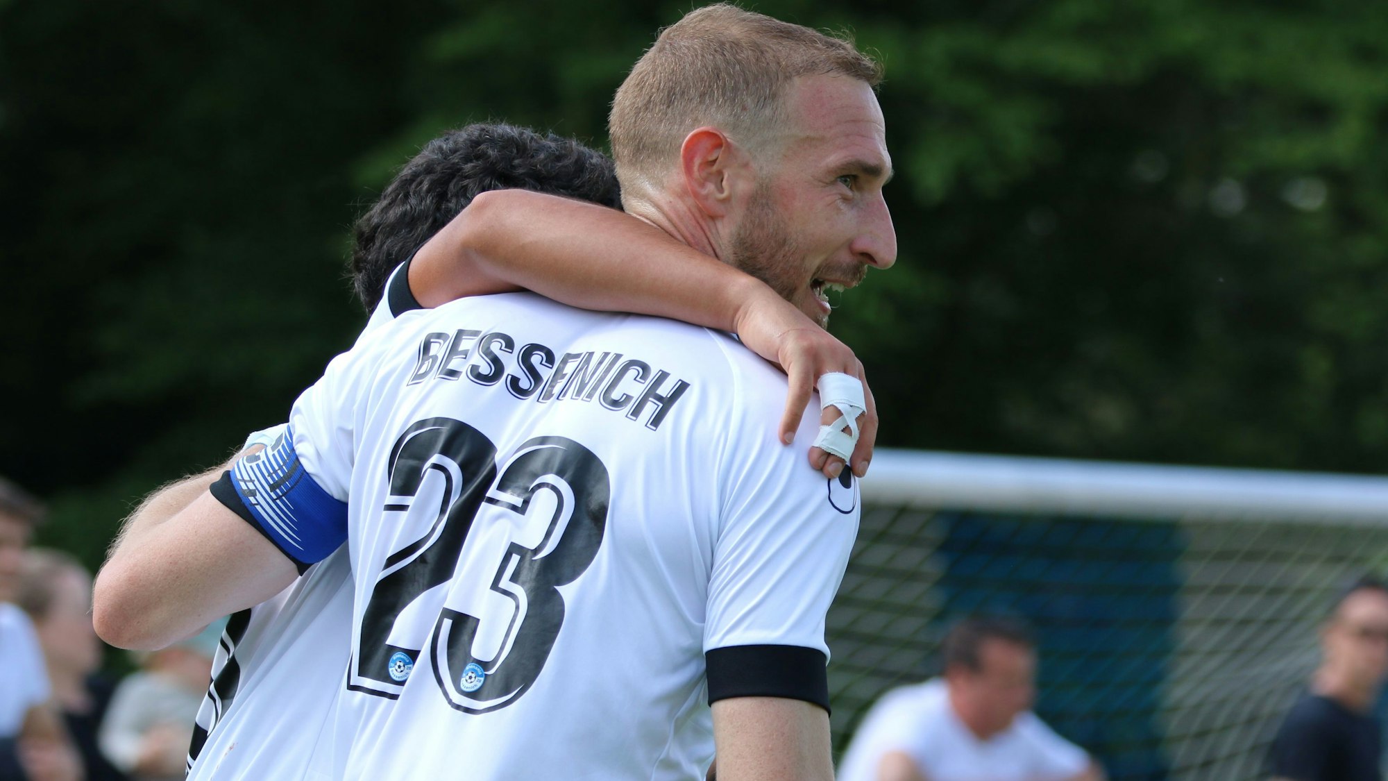 Moritz Hartmann lacht, ein Mitspieler hat ihm den Arm um die Schultern gelegt.