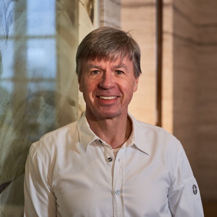 Herr Wissler ist im Porträt zu sehen. Er lacht in die Kamera.