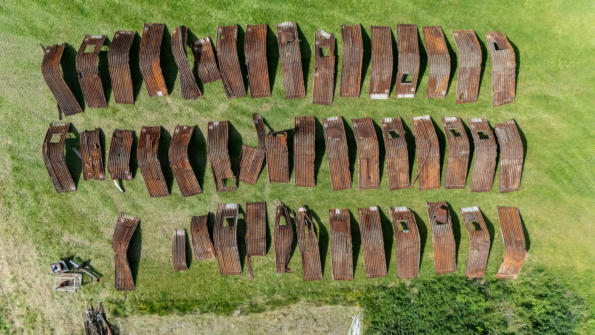 Die großen rostigen Blechteile sind sortiert, viele müssen repariert werden, bevor sie wieder zusammengebaut werden können.